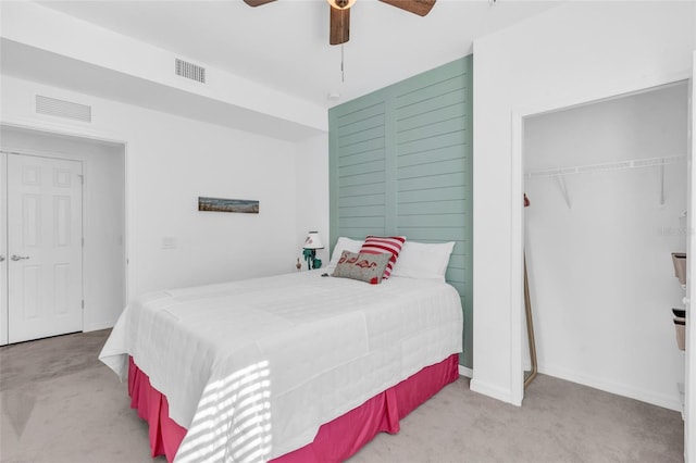 carpeted bedroom with ceiling fan and a closet