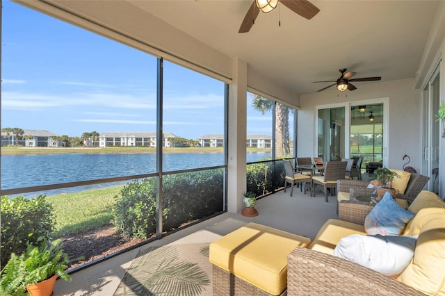 sunroom featuring a water view, ceiling fan, and a healthy amount of sunlight