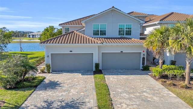 mediterranean / spanish-style house featuring a water view and a garage