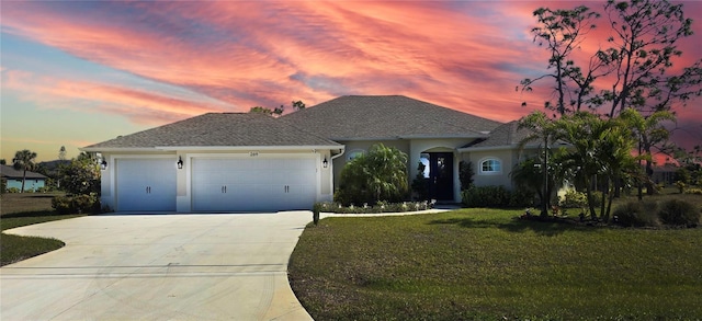 single story home featuring a garage and a lawn