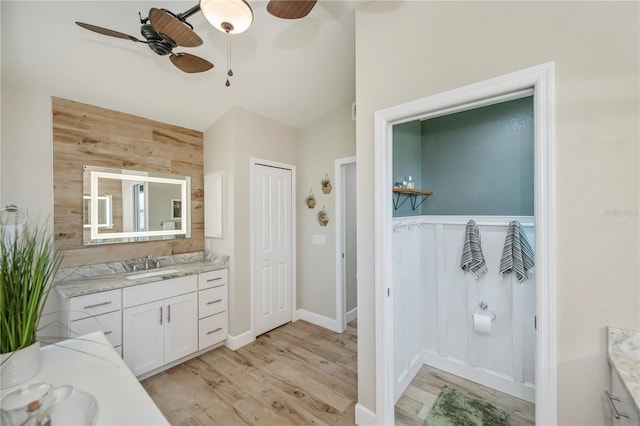 bathroom featuring hardwood / wood-style flooring, vanity, lofted ceiling, and ceiling fan