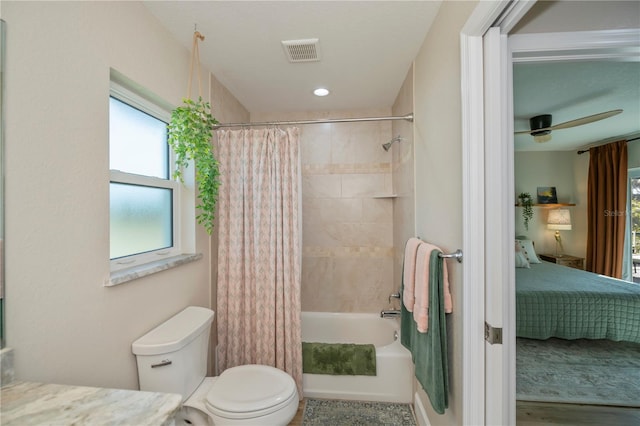 full bathroom featuring shower / bathtub combination with curtain, ceiling fan, plenty of natural light, and toilet