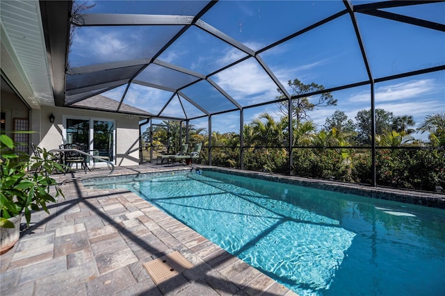 view of pool with a patio area and glass enclosure