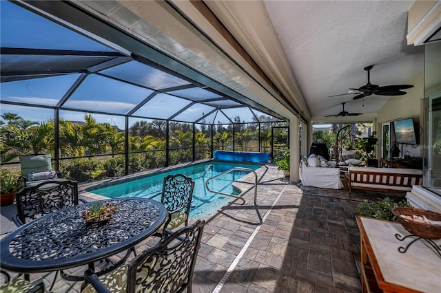 view of pool featuring a lanai, a patio area, and ceiling fan