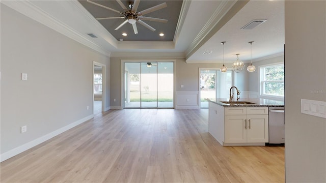 kitchen featuring light stone countertops, white cabinets, dishwasher, sink, and a tray ceiling