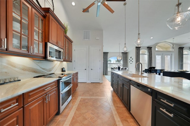 kitchen featuring decorative light fixtures, tasteful backsplash, sink, light tile patterned floors, and stainless steel appliances