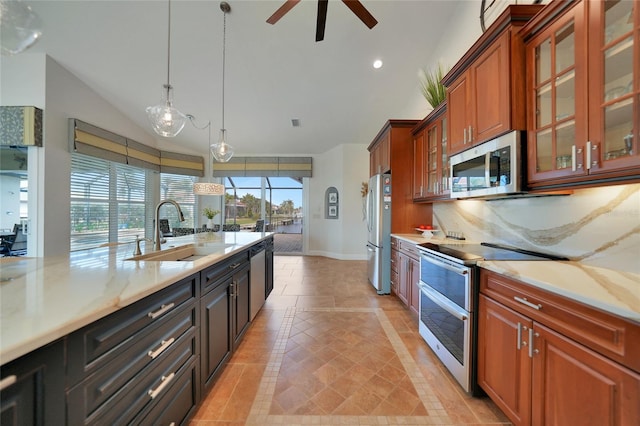 kitchen featuring sink, appliances with stainless steel finishes, backsplash, hanging light fixtures, and light stone countertops