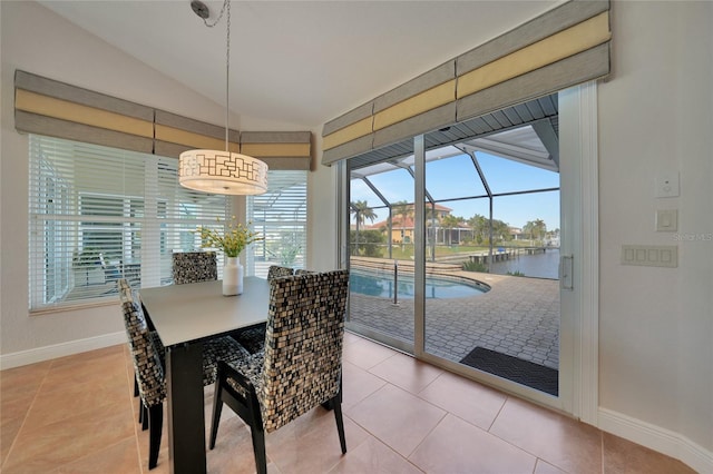 tiled dining area with vaulted ceiling and a water view