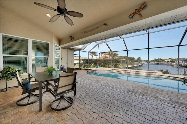 view of swimming pool featuring a lanai, a patio area, ceiling fan, and a water view