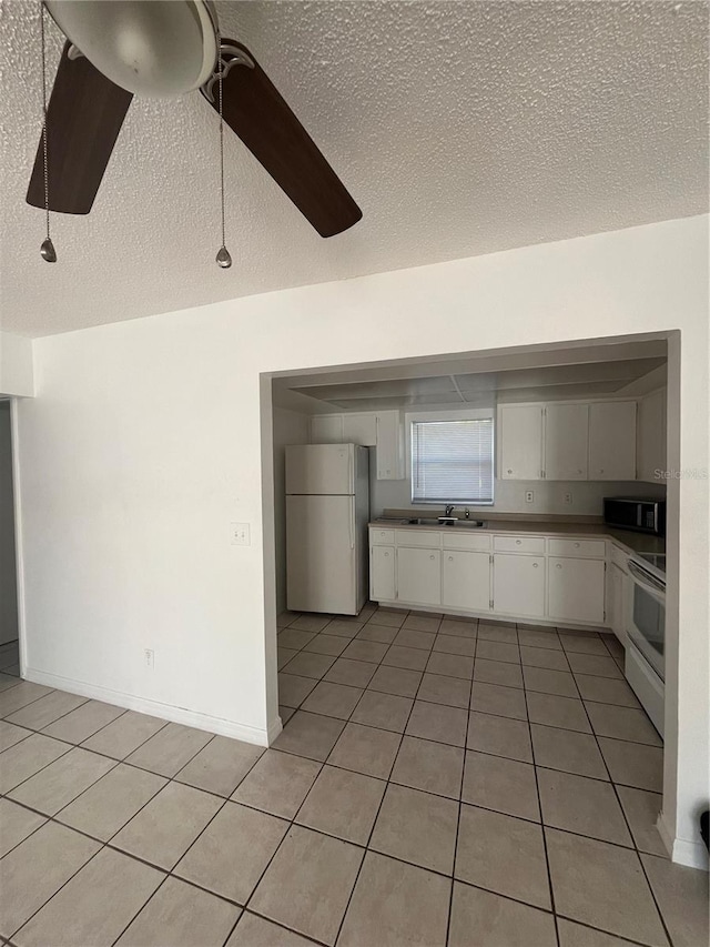 kitchen with light tile patterned flooring, sink, ceiling fan, white appliances, and white cabinets