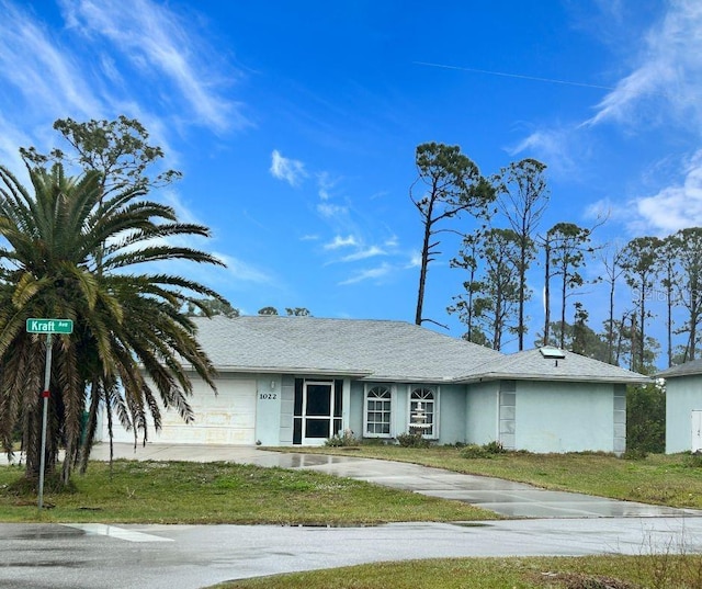 view of front of property with a garage and a front lawn