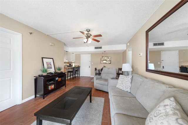 living room featuring a textured ceiling and ceiling fan