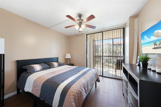 bedroom featuring dark wood-type flooring, ceiling fan, a textured ceiling, and access to outside