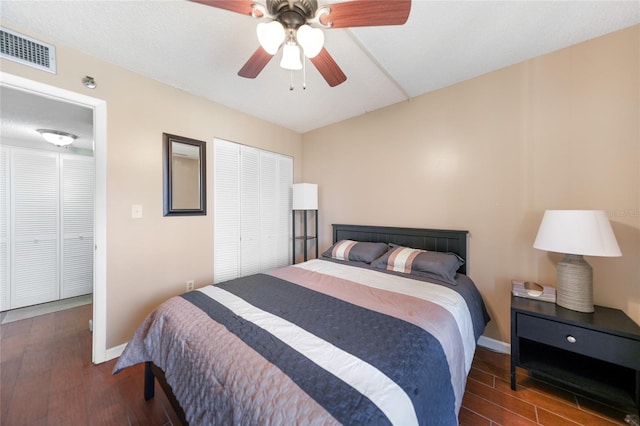 bedroom with a closet, dark hardwood / wood-style floors, and ceiling fan