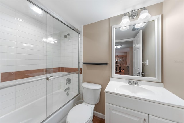 full bathroom with enclosed tub / shower combo, vanity, and toilet