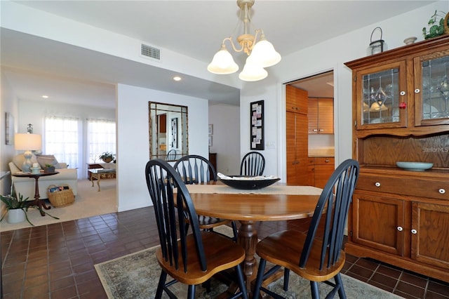 dining room featuring a notable chandelier and dark tile patterned floors