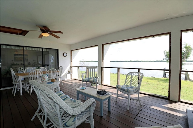 sunroom / solarium featuring a water view, a healthy amount of sunlight, and ceiling fan