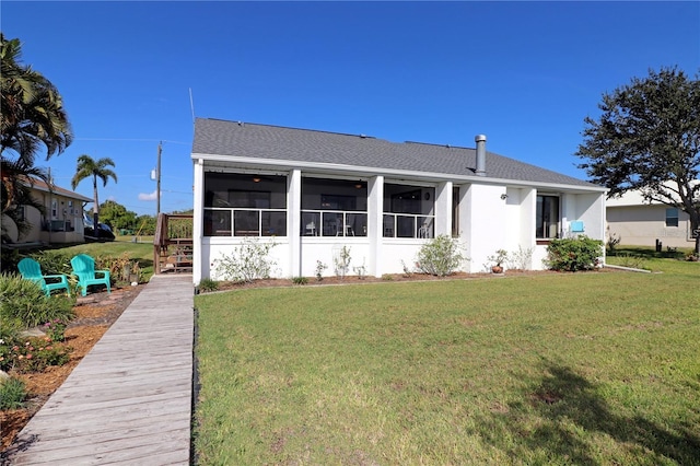 rear view of property with a sunroom and a lawn