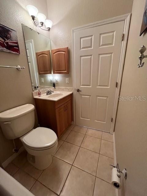 bathroom featuring a notable chandelier, vanity, tile patterned floors, and toilet