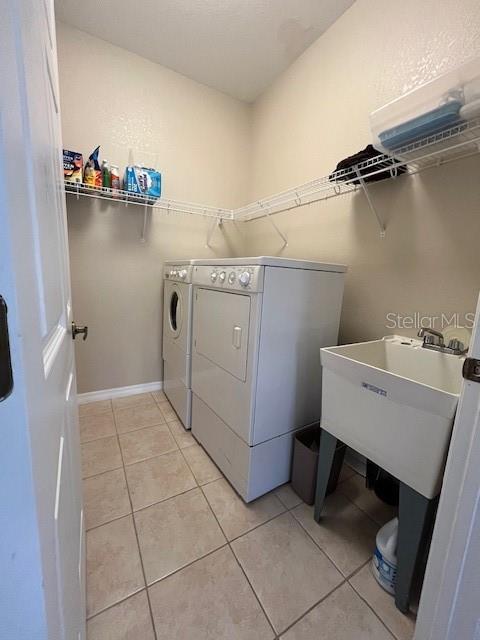 washroom with light tile patterned flooring and washer and clothes dryer