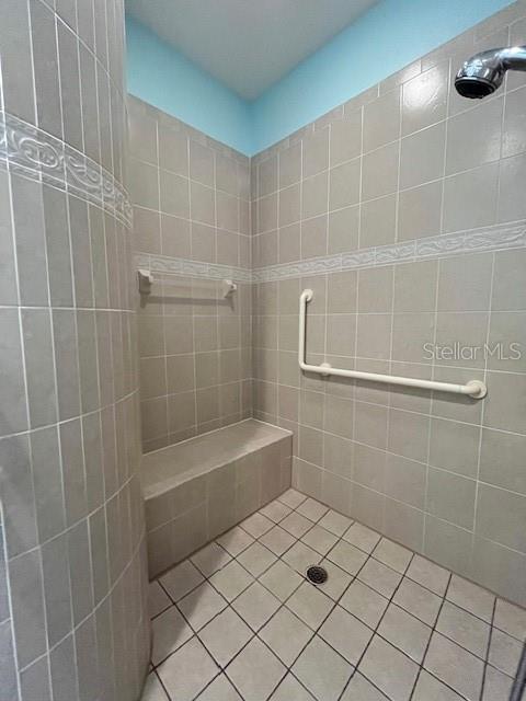 bathroom with tile patterned floors and a tile shower