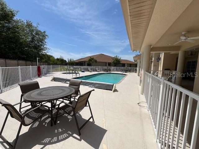 community pool with fence and a patio