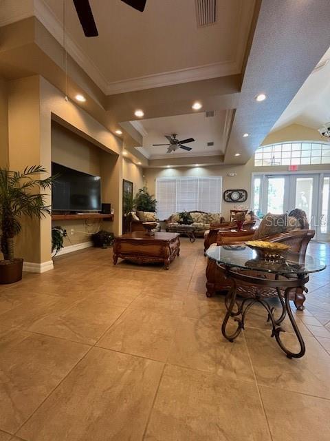 living area with visible vents, recessed lighting, ceiling fan, crown molding, and a raised ceiling