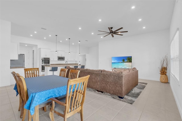 tiled dining area featuring ceiling fan and sink