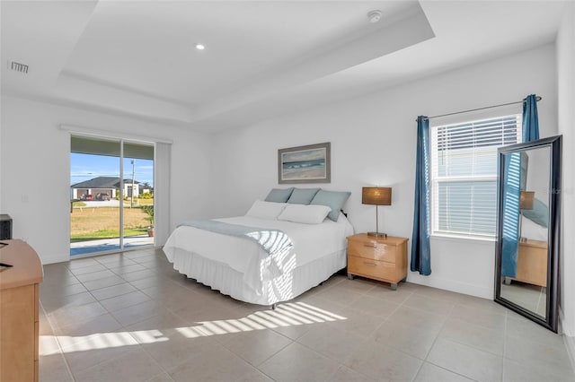 tiled bedroom featuring access to outside and a tray ceiling