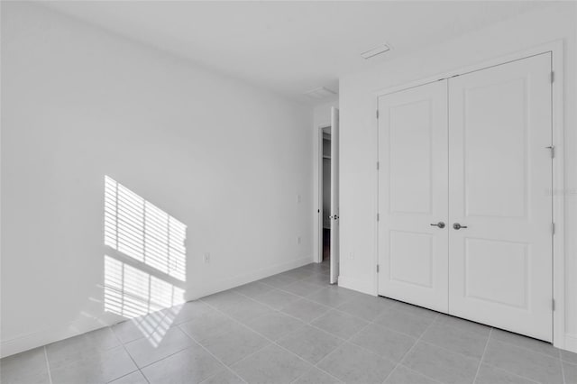 unfurnished bedroom with a closet and light tile patterned flooring