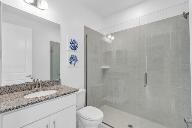 bathroom featuring vanity, toilet, and a shower with shower door