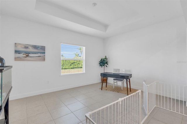 tiled home office featuring a raised ceiling