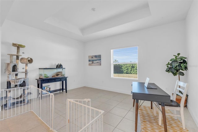 office with light tile patterned flooring and a tray ceiling