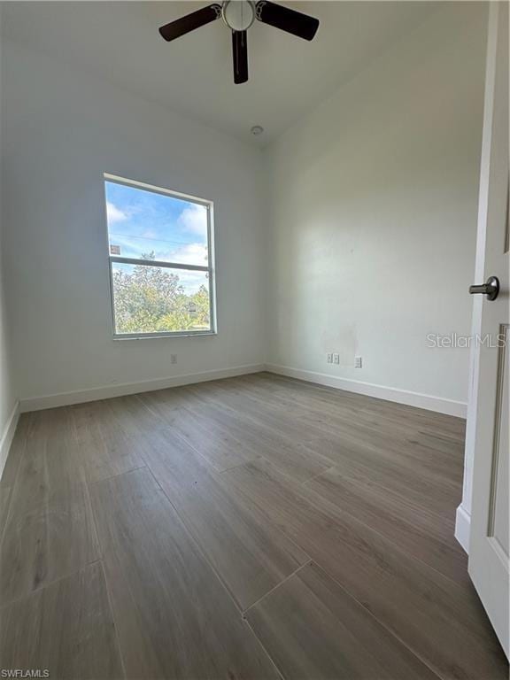 unfurnished room featuring dark wood-type flooring and ceiling fan