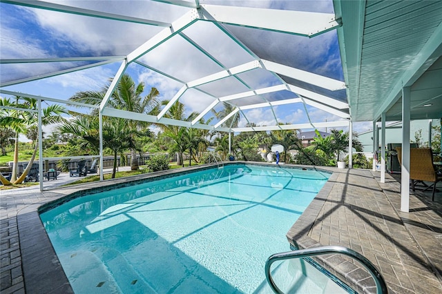 view of pool featuring glass enclosure and a patio area