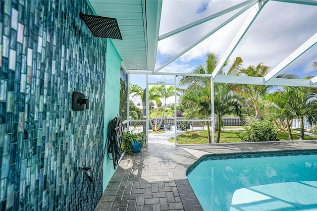 view of swimming pool with a patio and a lanai