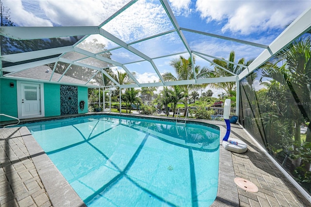 view of pool with a patio area and glass enclosure