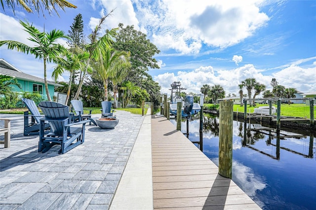 dock area with an outdoor fire pit and a water view