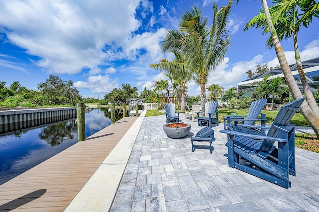 exterior space with a water view, an outdoor fire pit, and a patio area