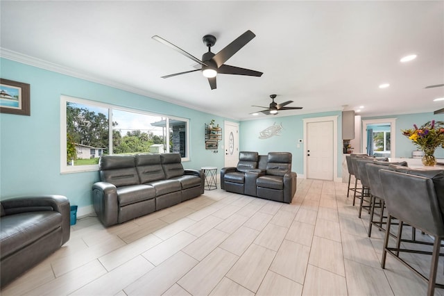 living room featuring crown molding, a healthy amount of sunlight, and ceiling fan