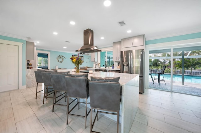 kitchen featuring sink, gray cabinetry, island exhaust hood, stainless steel fridge with ice dispenser, and crown molding