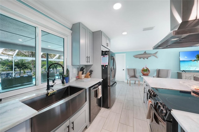 kitchen featuring crown molding, gray cabinets, appliances with stainless steel finishes, light stone counters, and extractor fan