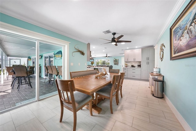 dining area with crown molding and ceiling fan