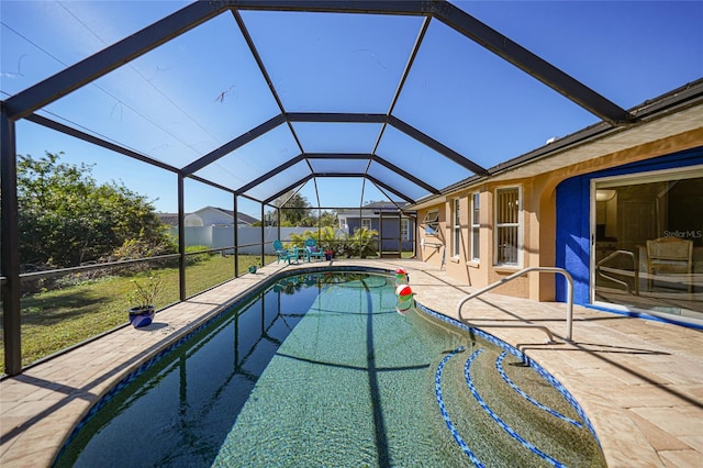 view of pool with a yard, a patio, and glass enclosure