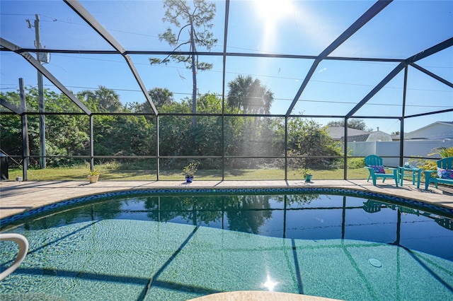 view of pool with a patio area and glass enclosure