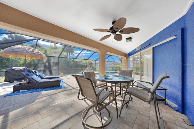 sunroom / solarium with plenty of natural light, lofted ceiling, and ceiling fan