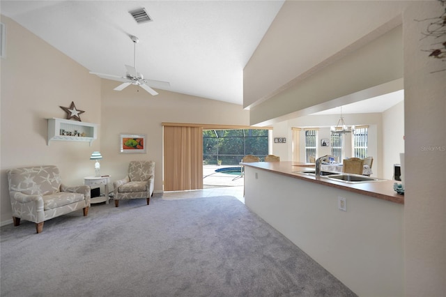 interior space featuring ceiling fan with notable chandelier, sink, light carpet, and high vaulted ceiling