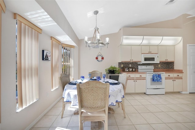 tiled dining room with lofted ceiling and a chandelier