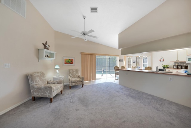 unfurnished room featuring light carpet, ceiling fan with notable chandelier, and high vaulted ceiling