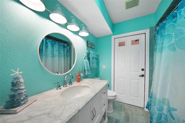 bathroom with vanity, toilet, curtained shower, and hardwood / wood-style floors